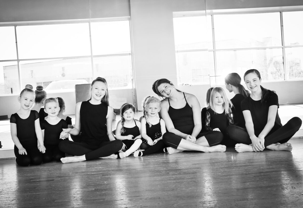 students sitting on dance class floor