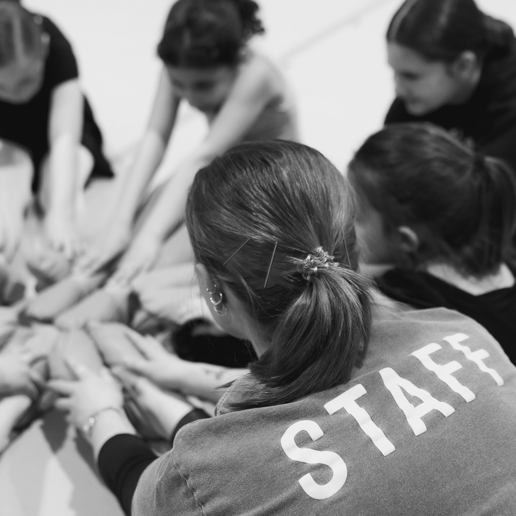 Dance teacher stretching with students during jazz class at Elite Dance Academy